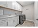 Well-organized laundry room with modern washer and dryer, ample cabinet space, and stylish countertops at 22990 Scaglione Dr, Lutz, FL 33549