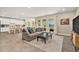Open-concept living area with a modern kitchen, comfortable seating, and large windows offering beautiful backyard views at 22990 Scaglione Dr, Lutz, FL 33549