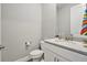 Compact powder room featuring a white vanity with granite countertop and sleek fixtures at 22990 Scaglione Dr, Lutz, FL 33549