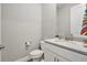 Elegant powder room featuring a granite countertop, modern fixtures, and a pristine white toilet at 22990 Scaglione Dr, Lutz, FL 33549