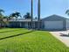 Charming single-story home with a well-maintained lawn and an attached two-car garage at 230 S Julia Cir, St Pete Beach, FL 33706