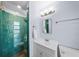 Bright and modern bathroom with white vanity, glass shower door and unique teal tile at 2905 Bay St, Sarasota, FL 34237