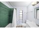 Bathroom with modern fixtures, green shower tiling, and bright natural light from the window at 2905 Bay St, Sarasota, FL 34237