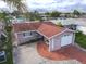 Aerial view of a charming single-story home with a well-maintained roof, brick driveway, and attached garage in quiet neighborhood at 5033 Blue Heron Dr, New Port Richey, FL 34652