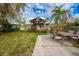 Landscaped backyard featuring a covered wooden gazebo, outdoor seating, and a concrete patio perfect for entertaining guests at 5033 Blue Heron Dr, New Port Richey, FL 34652