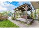 Backyard featuring a wooden gazebo covering a hot tub, surrounded by lush greenery and a spiral staircase to a second story deck at 5033 Blue Heron Dr, New Port Richey, FL 34652