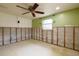 Bedroom showing studs for new walls with natural light and ceiling fan at 5033 Blue Heron Dr, New Port Richey, FL 34652