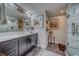 Well-lit bathroom boasts a long countertop with a large mirror and walk-in shower at 6 Belleview Blvd # 203, Belleair, FL 33756