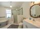 Bright bathroom featuring a glass shower, vanity with sink, toilet, and window at 602 Nw Drane St, Plant City, FL 33563
