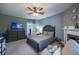Spacious bedroom with neutral tones, ceiling fan, and a cozy seating area at 602 Nw Drane St, Plant City, FL 33563