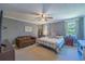 This bedroom boasts a cozy seating area, a ceiling fan, and two windows at 602 Nw Drane St, Plant City, FL 33563