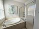 Bathroom showcasing a soaking tub and separate glass-enclosed shower with neutral tiling at 6400 Falcon Lair Dr, North Port, FL 34287