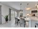 Bright dining area with modern lighting and windows with patterned black and white curtains at 7528 Paradiso Dr, Apollo Beach, FL 33572