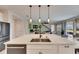 Spacious kitchen island with modern pendant lighting, stainless steel sink, and sleek appliances at 7528 Paradiso Dr, Apollo Beach, FL 33572
