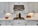 Contemporary kitchen featuring white cabinetry, granite countertops, and a sleek gas range at 7528 Paradiso Dr, Apollo Beach, FL 33572