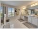 Bright bathroom with double sink vanity, glass enclosed shower, and tile floors at 7528 Paradiso Dr, Apollo Beach, FL 33572