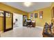 A well-lit home office with light tile floors, warm yellow walls and a traditional desk setup at 7528 Paradiso Dr, Apollo Beach, FL 33572