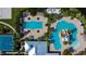 Aerial view of community pool area with lap pool, slide, lounge chairs, and nearby sports courts at 7528 Paradiso Dr, Apollo Beach, FL 33572