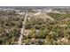 Drone shot showcases the property with the pool, close to nearby amenities, all surrounded by mature trees at 9641 Fulton Ave, Hudson, FL 34667