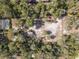 Expansive aerial view of a secluded lot surrounded by lush trees, and a screened in pool visible at 9641 Fulton Ave, Hudson, FL 34667