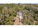 A high aerial view showcases the house with a screened pool surrounded by a canopy of trees at 9641 Fulton Ave, Hudson, FL 34667