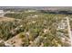 Aerial view of a large property nestled among mature trees, showcasing the surrounding neighborhood and waterfront views at 9641 Fulton Ave, Hudson, FL 34667