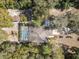 Aerial view of a home featuring a screened pool and a spacious yard with mature landscaping at 9641 Fulton Ave, Hudson, FL 34667