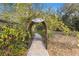 Picturesque path framed by an archway, leading into a charming farm setting at 9641 Fulton Ave, Hudson, FL 34667