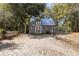 Charming barn with a metal roof, set in a yard surrounded by trees and a small fence at 9641 Fulton Ave, Hudson, FL 34667