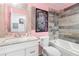 Bathroom boasts pink walls, a wood accent mirror, and a tub-shower combo at 9641 Fulton Ave, Hudson, FL 34667
