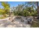 Inviting fire pit area with ample seating made of tree stumps and brick paver flooring at 9641 Fulton Ave, Hudson, FL 34667