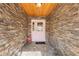 Inviting front entryway featuring a decorative pink door, stone walls, and stylish flooring at 9641 Fulton Ave, Hudson, FL 34667