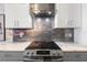 Contemporary kitchen featuring a stainless steel range hood, cooktop, and modern backsplash at 9641 Fulton Ave, Hudson, FL 34667
