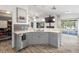 Open kitchen with gray cabinetry, marble countertops, stainless steel appliances, and brick accents at 9641 Fulton Ave, Hudson, FL 34667
