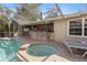This outdoor pool features an attached spa and seating area, perfect for enjoying warm days and cool evenings at 9641 Fulton Ave, Hudson, FL 34667
