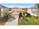 Single-story home with mature landscaping, a two-car garage, and a red front door at 11444 Village Brook Dr, Riverview, FL 33579