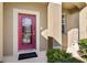 Close-up of a red front door with decorative glass and a tiled porch at 11444 Village Brook Dr, Riverview, FL 33579