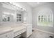 Bright bathroom featuring ample counterspace, ample mirrors, and an arch-top window at 11505 Heron Hills Ln, Riverview, FL 33569