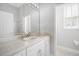 Bright bathroom with a large mirror, white cabinets, and a neutral-toned tiled countertop at 11505 Heron Hills Ln, Riverview, FL 33569