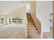 Living room featuring neutral carpet, staircase, and view of the lanai overlooking the lake at 2435 E Del Webb Blvd, Sun City Center, FL 33573