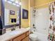 Stylish bathroom showcasing a decorative mirror, tub with shower, and colorful shower curtain at 25950 Risen Star Dr, Wesley Chapel, FL 33544