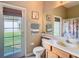 Bright bathroom featuring a door to the outside, vanity, and a large mirror reflecting the shower at 25950 Risen Star Dr, Wesley Chapel, FL 33544