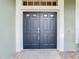 Elegant double front doors with charming textured walls and stone entry creating a warm and inviting entrance at 25950 Risen Star Dr, Wesley Chapel, FL 33544