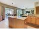 Spacious kitchen with granite countertops, stainless steel appliances, and a kitchen island overlooking the living space at 25950 Risen Star Dr, Wesley Chapel, FL 33544