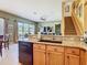 Spacious kitchen area with granite countertops, stainless steel appliances, open to the living room and staircase at 25950 Risen Star Dr, Wesley Chapel, FL 33544
