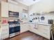 Charming kitchen with stainless steel appliances, white cabinets, and wood flooring at 25950 Risen Star Dr, Wesley Chapel, FL 33544