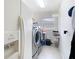Bright laundry room features modern washer and dryer units with tile flooring at 25950 Risen Star Dr, Wesley Chapel, FL 33544