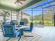 Inviting screened-in patio featuring comfortable seating, a grill, and scenic backyard views at 25950 Risen Star Dr, Wesley Chapel, FL 33544