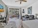 Cozy bedroom featuring a gray reclining sofa, a desk, and sliding doors leading to a balcony at 3106 Bayshore Oaks Dr, Tampa, FL 33611