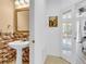 Compact half bathroom featuring a pedestal sink, tile accents, and a glass door to the bedroom at 3106 Bayshore Oaks Dr, Tampa, FL 33611